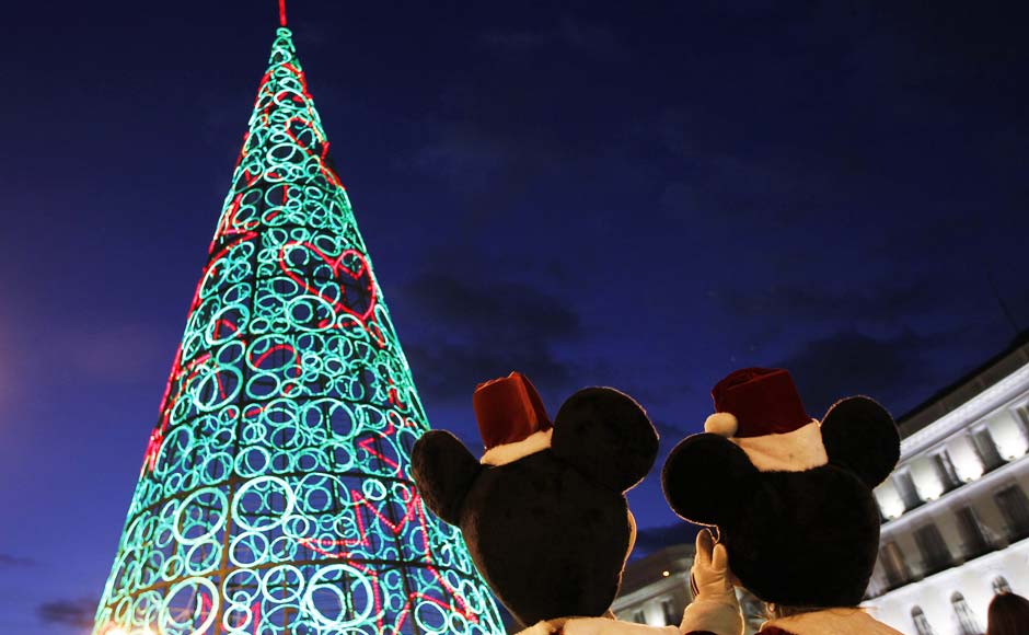 Two people dressed as Mickey Mouse stand next to a Christmas tree made out of lights in Spain. Reuters Two people dressed as Mickey Mouse stand next to a Christmas tree made out of lights in Spain. Reuters