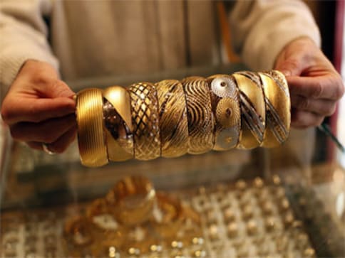 Investors nervous after Fitch warning, gold edges lower