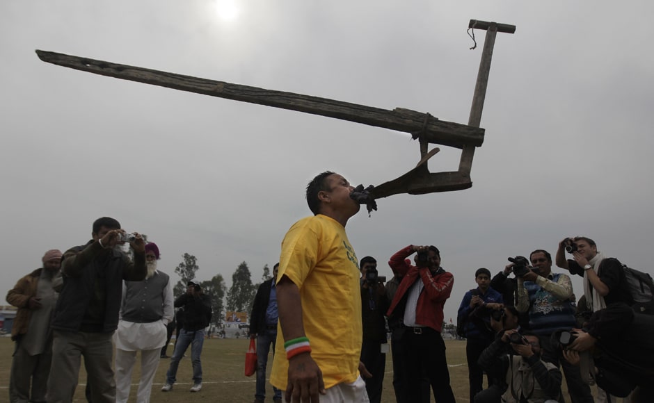 A villager balances a plough in his mouth during the rural sports festival. AP A villager balances a plough in his mouth during the rural sports festival. AP