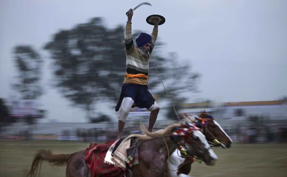 A Sikh warrior rides on two horses during a rural sports festival, also known as "Indian Rural Olympics". AP A Sikh warrior rides on two horses during a rural sports festival, also known as "Indian Rural Olympics". AP