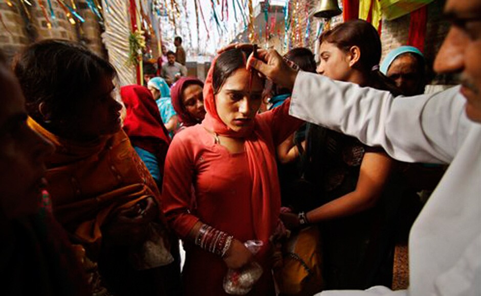 A Hindu priest puts vermilion on the forehead of a devotee at the historical Kali Temple on the third day of the Navratri. AP A Hindu priest puts vermilion on the forehead of a devotee at the historical Kali Temple on the third day of the Navratri. AP