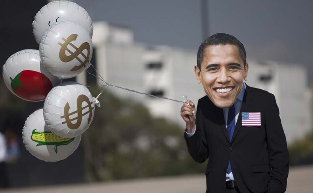 An Oxfam activist wears a mask depicting President Barack Obama holds balloons decorated with dollar signs and food during a protest in Mexico City. Alexandre Meneghini/AP An Oxfam activist wears a mask depicting President Barack Obama holds balloons decorated with dollar signs and food during a protest in Mexico City. Alexandre Meneghini/AP