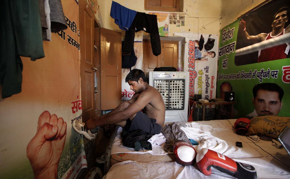 An amateur boxer gets ready for a training session in his room at the Sports Authority of India complex, in Bhiwani. AP An amateur boxer gets ready for a training session in his room at the Sports Authority of India complex, in Bhiwani. AP
