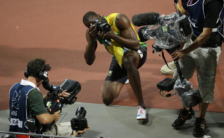 Jamaica's Usain Bolt, center, takes photographs after he won gold in the men's 200-meter final during the athletics. Charlie Riedel/AP Jamaica's Usain Bolt, center, takes photographs after he won gold in the men's 200-meter final during the athletics. Charlie Riedel/AP