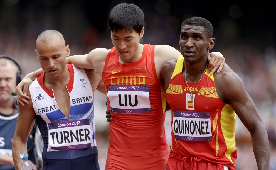 China's Liu Xiang is helped off the track by Britain's Andrew Turner, left, and Spain's Jackson Quinonez after falling in a men's 110-meter hurdles heat. AP China's Liu Xiang is helped off the track by Britain's Andrew Turner, left, and Spain's Jackson Quinonez after falling in a men's 110-meter hurdles heat. AP