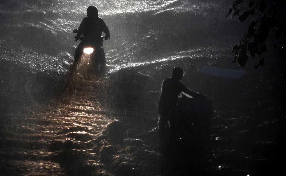Commuters wade through a flooded street during monsoon rains in Mumbai. Rafiq Maqbool/AP Commuters wade through a flooded street during monsoon rains in Mumbai. Rafiq Maqbool/AP