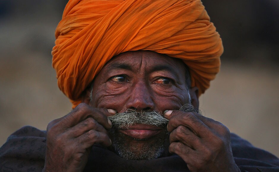 A camel herder plays with his moustache as he sits at the annual Pushkar Fair. Kevin Frayer/ AP A camel herder plays with his moustache as he sits at the annual Pushkar Fair. Kevin Frayer/ AP