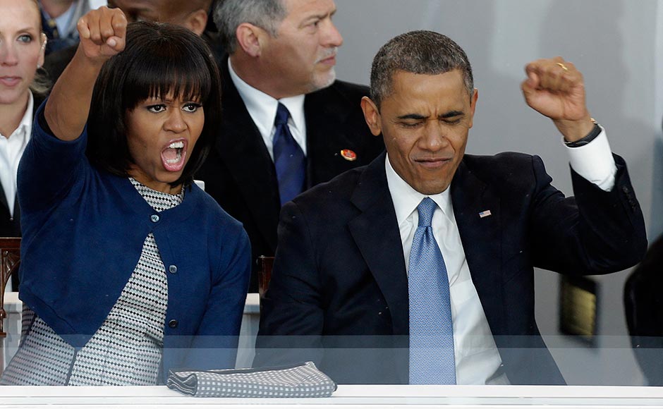 President Barack Obama and first lady Michelle Obama cheer as bands march past the presidential box near the White House. Gerald Herbert/AP President Barack Obama and first lady Michelle Obama cheer as bands march past the presidential box near the White House. Gerald Herbert/AP
