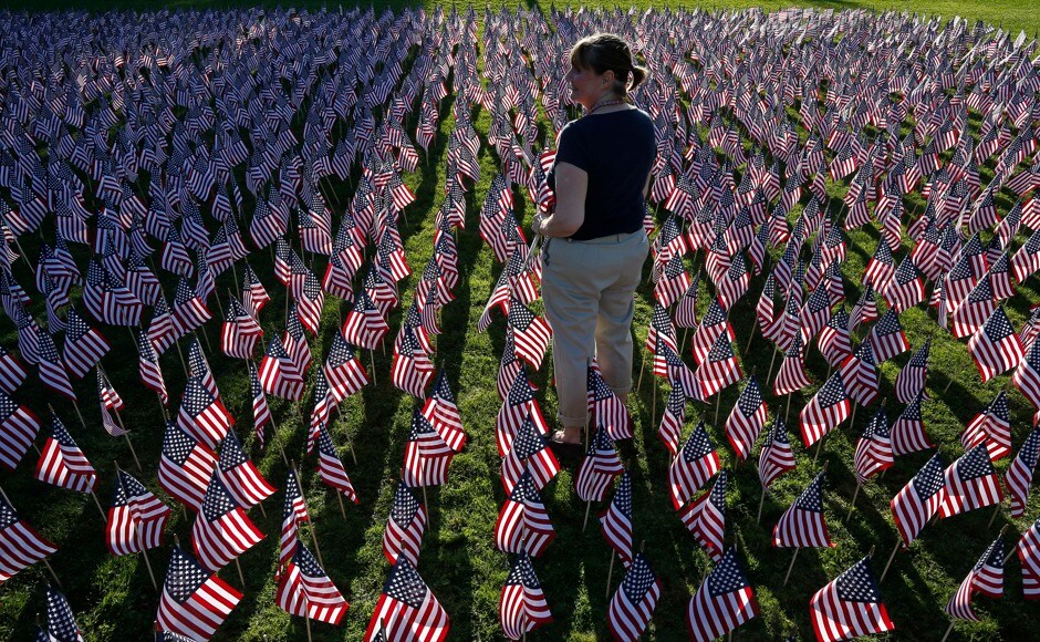 A woman stands among some of the 3,000 flags placed in memory of the lives lost in the September 11, 2001 attacks, at a park in Winnetka, Illinois, on 10 September, 2014. Reuters A woman stands among some of the 3,000 flags placed in memory of the lives lost in the September 11, 2001 attacks, at a park in Winnetka, Illinois, on 10 September, 2014. Reuters
