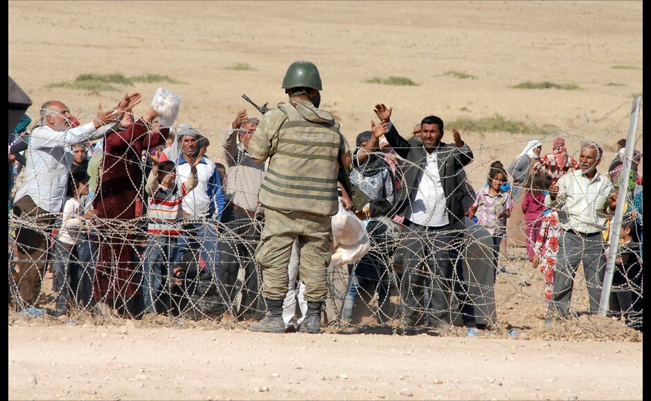 Syrian Kurds plead guards from behind the fence to to allow them to cross the Turkish border. Several thousand Syrian Kurds began crossing into Turkey on Friday, fleeing Islamic State fighters who advanced into their villages. Reuters Syrian Kurds plead guards from behind the fence to to allow them to cross the Turkish border. Several thousand Syrian Kurds began crossing into Turkey on Friday, fleeing Islamic State fighters who advanced into their villages. Reuters