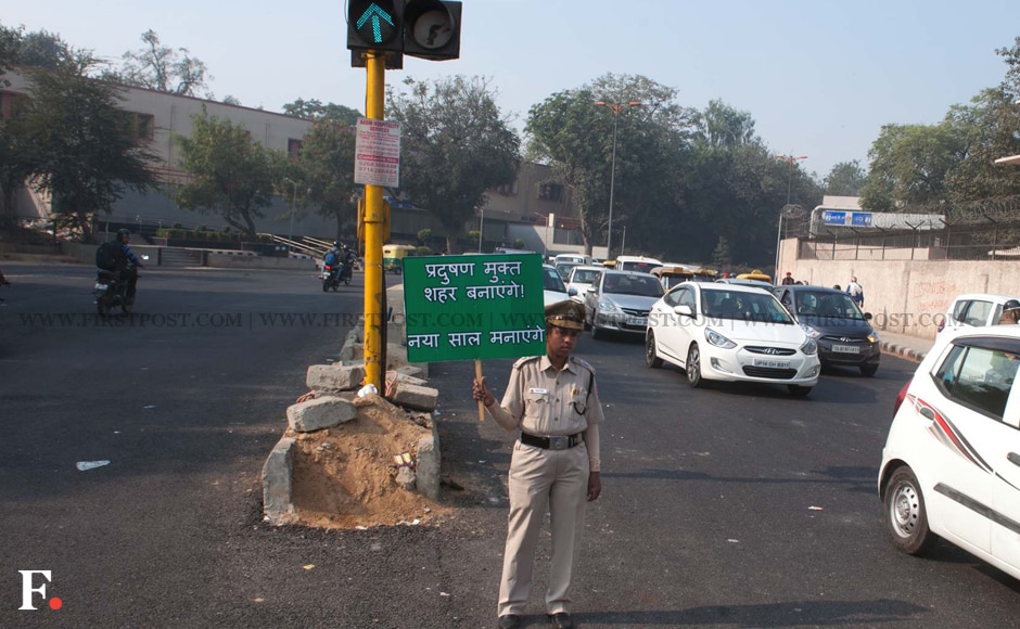 A police personnel holds up a placard for a 'pollution-free city.' The initiative will be tried out over a period of 15 days starting from 1 January. Image: Naresh Sharma/Firstpost A police personnel holds up a placard for a 'pollution-free city.' The initiative will be tried out over a period of 15 days starting from 1 January. Image: Naresh Sharma/Firstpost