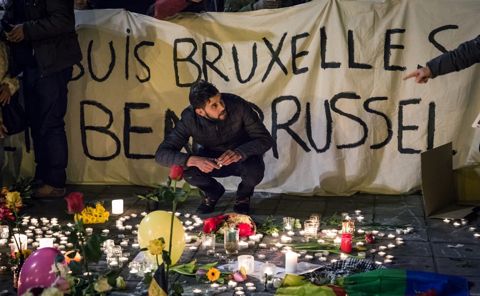 People hold a banner reading in French and Flamish "I am Brussels" as they gather around floral tributes, candles, belgian flags and notes in front of the Bourse of Brussels on 22 March in tribute to the victims of Brussels. AFP People hold a banner reading in French and Flamish "I am Brussels" as they gather around floral tributes, candles, belgian flags and notes in front of the Bourse of Brussels on 22 March in tribute to the victims of Brussels. AFP