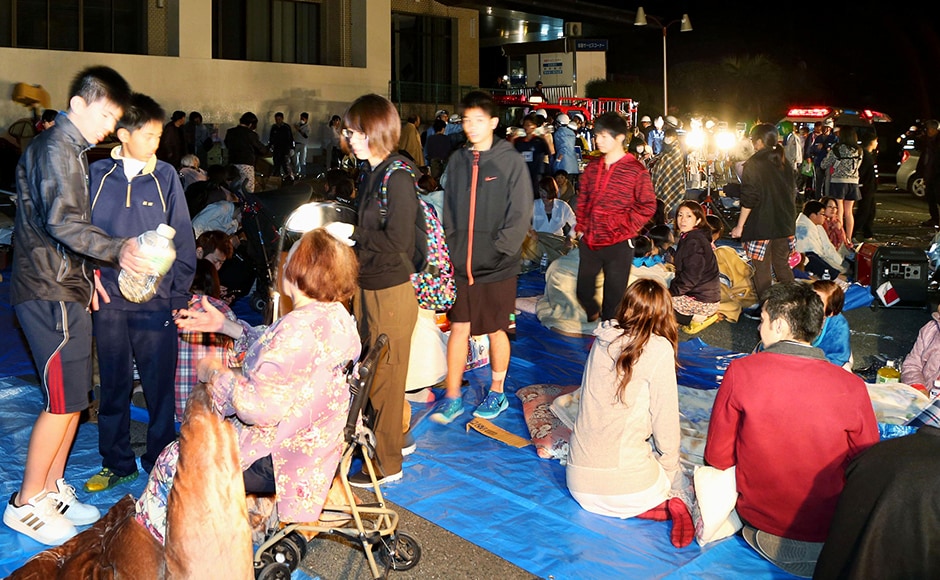 Stranded people gather outside a town hall of Mashiki, after the earthquake. Japanese broadcaster NHK showed Mashiki town hall in the dark, apparently having lost power. Footage also showed rubble on the road, shards of glasses and broken windows, and fire breaking out in some places, with firefighters battling an orange blaze. AP Stranded people gather outside a town hall of Mashiki, after the earthquake. Japanese broadcaster NHK showed Mashiki town hall in the dark, apparently having lost power. Footage also showed rubble on the road, shards of glasses and broken windows, and fire breaking out in some places, with firefighters battling an orange blaze. AP