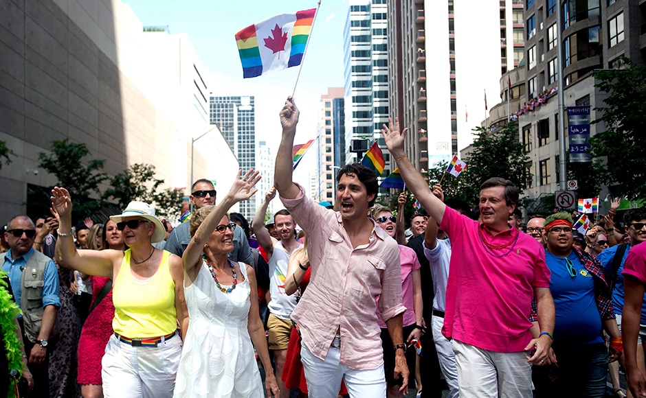 (Left to right) Ontario Premier Kathleen Wynne, Prime Minister Justin Trudeau and Toronto Mayor John Tory march with tens of thousands of people in Toronto's Gay Pride parade. Photo Courtesy: AP (Left to right) Ontario Premier Kathleen Wynne, Prime Minister Justin Trudeau and Toronto Mayor John Tory march with tens of thousands of people in Toronto's Gay Pride parade. Photo Courtesy: AP