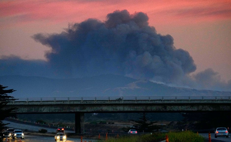 A large plume of smoke from a wildfire rises near Highway 1, burning five miles south of Carmel, California, on 22 July. AP A large plume of smoke from a wildfire rises near Highway 1, burning five miles south of Carmel, California, on 22 July. AP