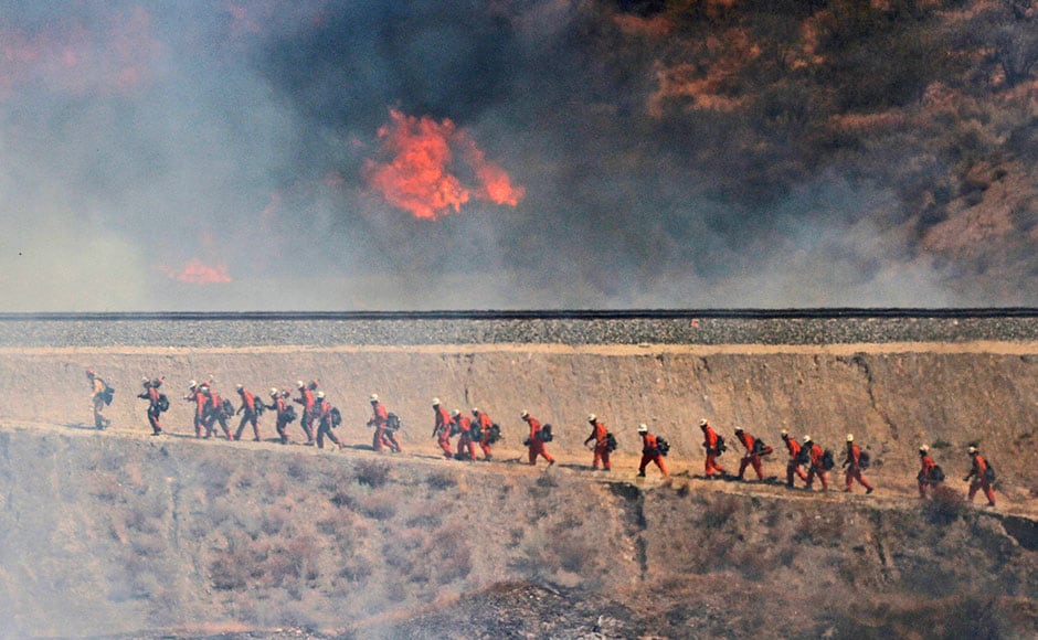 A fire crew approaches as a wildfire burns in Santa Clarita, Calif. The fire erupted shortly after 2 p.m. Friday next to State Route 14 in Santa Clarita. No homes are immediately threatened, but fire officials say evacuations have been ordered from Soledad Canyon to Agua Dulce Canyon Road. AP A fire crew approaches as a wildfire burns in Santa Clarita, Calif. The fire erupted shortly after 2 p.m. Friday next to State Route 14 in Santa Clarita. No homes are immediately threatened, but fire officials say evacuations have been ordered from Soledad Canyon to Agua Dulce Canyon Road. AP