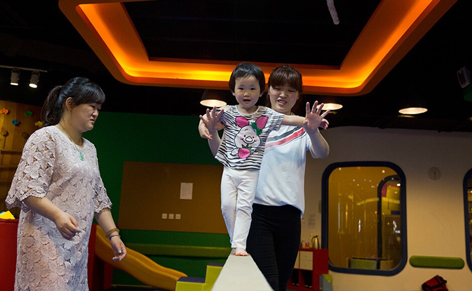A child is supported on a balance beam at the Inspire Sports private gym in Shanghai, China. The scene of giggling children having fun and attempting somersaults or gingerly walking on low balance beam is a rare sight in China where gym lessons usually evokes stereotypical images of tearful children practicing splits. However Chinese sports officials believe this sort of spontaneous interest in the sport is a welcome step to fundamentally change China's current elite sports system. AP A child is supported on a balance beam at the Inspire Sports private gym in Shanghai, China. The scene of giggling children having fun and attempting somersaults or gingerly walking on low balance beam is a rare sight in China where gym lessons usually evokes stereotypical images of tearful children practicing splits. However Chinese sports officials believe this sort of spontaneous interest in the sport is a welcome step to fundamentally change China's current elite sports system. AP