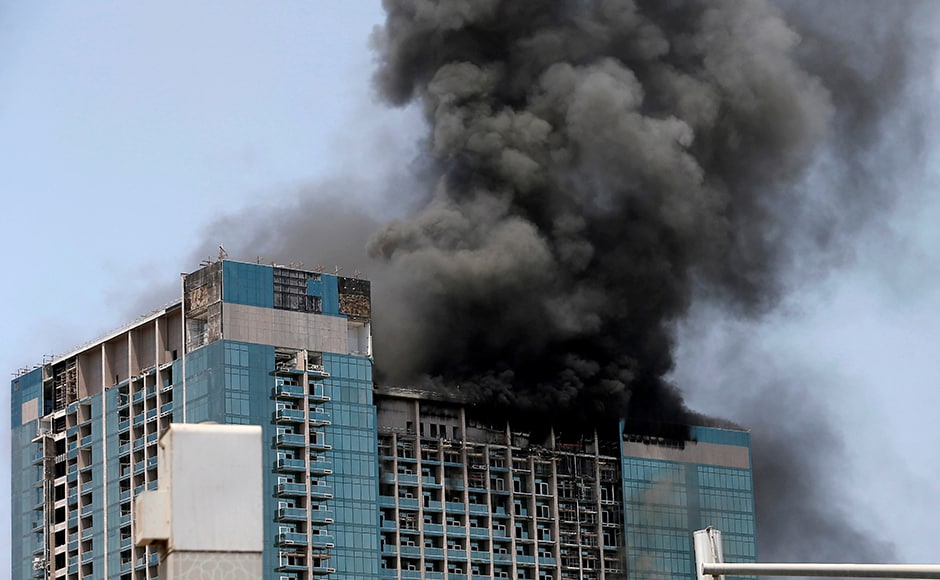 Thick black smoke billowed from the top 20 floors of the almost-completed commercial building in the UAE's capital and firefighters, overseen by helicopters, were working to put the blaze out two hours after it started. Reuters Thick black smoke billowed from the top 20 floors of the almost-completed commercial building in the UAE's capital and firefighters, overseen by helicopters, were working to put the blaze out two hours after it started. Reuters