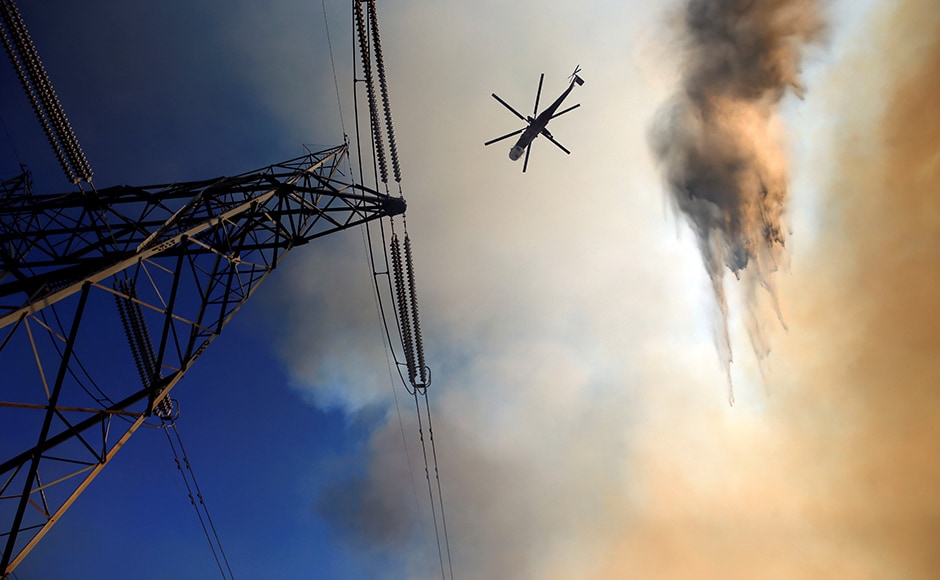 Firefighters described the blaze as unusually fierce, even for a year of intense wildfires in the US West, where years of drought have placed a heavy burden on firefighting resources. A firefighting helicopter maneuvers around power lines and smoke to make a water drop during the fire. Reuters Firefighters described the blaze as unusually fierce, even for a year of intense wildfires in the US West, where years of drought have placed a heavy burden on firefighting resources. A firefighting helicopter maneuvers around power lines and smoke to make a water drop during the fire. Reuters