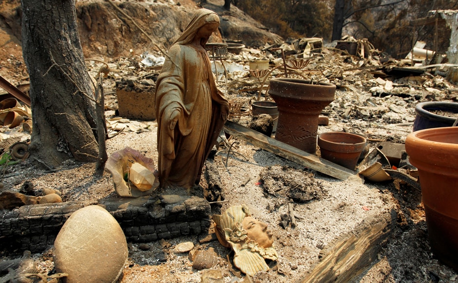 A charred Virgin Mary statue sits in a garden at the site of a destroyed home. In Central California, the fast-moving fire is being fueled by hundreds of dead trees amid triple-digit temperatures and single-digit humidity that are expected to last for several days. Reuters A charred Virgin Mary statue sits in a garden at the site of a destroyed home. In Central California, the fast-moving fire is being fueled by hundreds of dead trees amid triple-digit temperatures and single-digit humidity that are expected to last for several days. Reuters