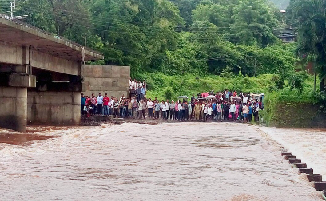 In Khed, Maharashtra, people were stuck on one end as a bridge is shut for traffic movement due to overflowing of stream following heavy rains in the city on Tuesday. PTI In Khed, Maharashtra, people were stuck on one end as a bridge is shut for traffic movement due to overflowing of stream following heavy rains in the city on Tuesday. PTI