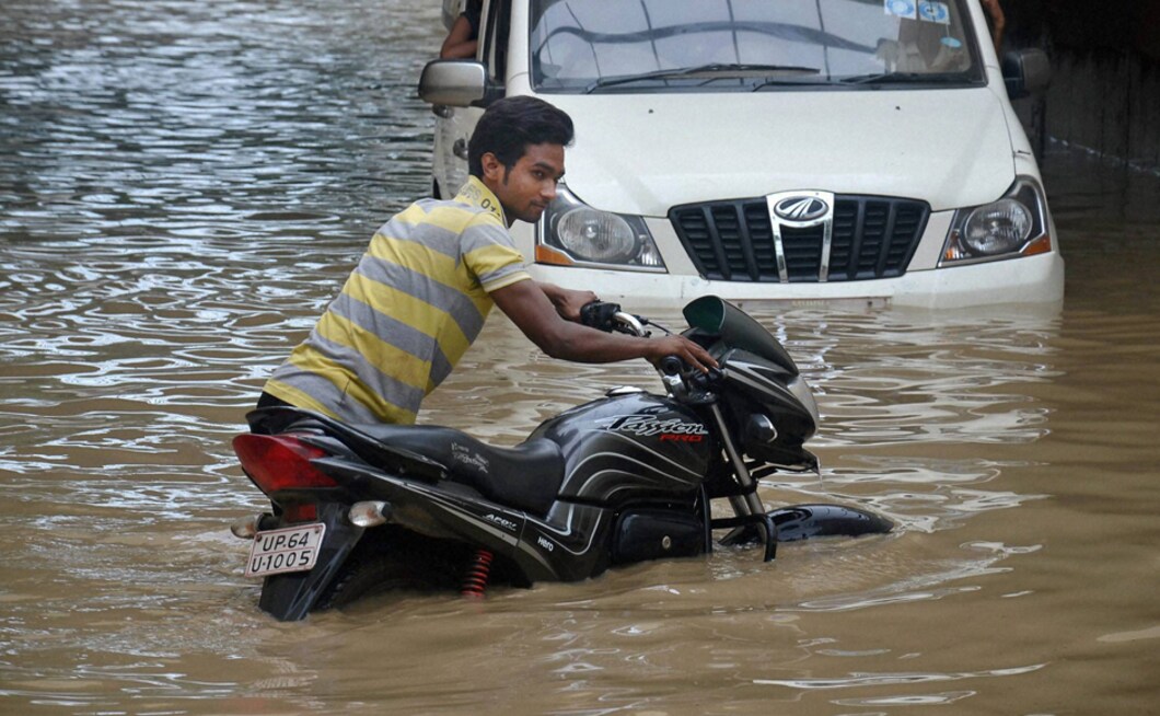 A boy pushes his bike through a flooded road after heavy rains in Mirzapur on Tuesday. Heavy rainfall continued to lash Uttar Pradesh with many rivers including the Ganga flowing near or above the danger mark, creating flood-like situation in several villages in the state. PTI A boy pushes his bike through a flooded road after heavy rains in Mirzapur on Tuesday. Heavy rainfall continued to lash Uttar Pradesh with many rivers including the Ganga flowing near or above the danger mark, creating flood-like situation in several villages in the state. PTI