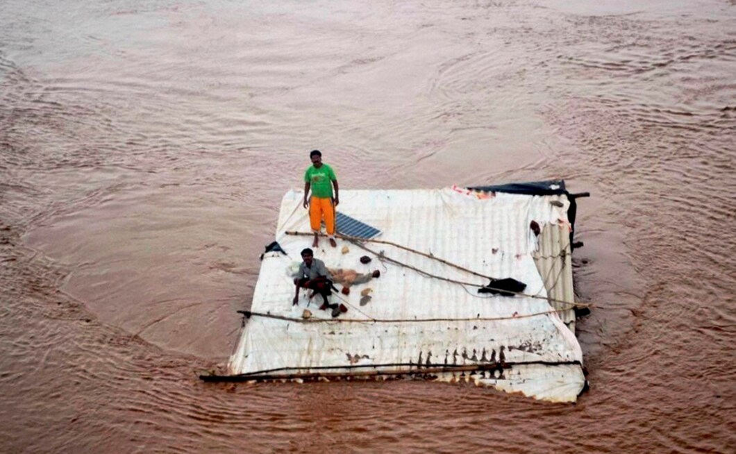 In Valsad, Maharashtra, a district North of Nashik, people were marooned on the top of a submerged house on Tuesday after heavy rains. Incessant rains pummelled the city and other parts of district on the third consecutive day, triggering flood in Godavari river which has crossed the danger mark in the Nashik and adjoining areas. PTI In Valsad, Maharashtra, a district North of Nashik, people were marooned on the top of a submerged house on Tuesday after heavy rains. Incessant rains pummelled the city and other parts of district on the third consecutive day, triggering flood in Godavari river which has crossed the danger mark in the Nashik and adjoining areas. PTI