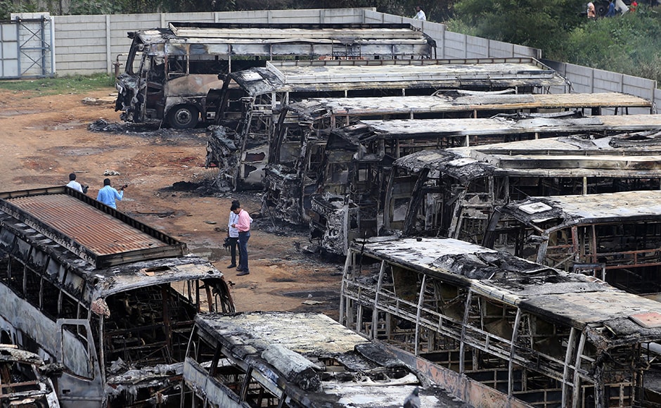 Charred remains of passenger buses, owned by a transport company from the neighboring Tamil Nadu state, lie in a yard a day after they were set ablaze by angry mobs in Bengaluru on Monday. (Photo: AP) Charred remains of passenger buses, owned by a transport company from the neighboring Tamil Nadu state, lie in a yard a day after they were set ablaze by angry mobs in Bengaluru on Monday. (Photo: AP)
