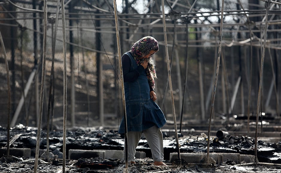 A migrant stands amid the burned remains of a tent at the camp. Refugees and migrants on Lesbos are stranded by a European Union deal with Turkey preventing them going beyond the island until their asylum claims have been processed. Reuters A migrant stands amid the burned remains of a tent at the camp. Refugees and migrants on Lesbos are stranded by a European Union deal with Turkey preventing them going beyond the island until their asylum claims have been processed. Reuters