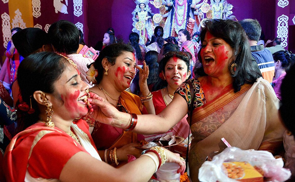 The Dashami rituals in the morning saw married women preparing the goddess and her children for their long journey back home by smearing the deities and each other with red vermilion. (Photo: PTI) The Dashami rituals in the morning saw married women preparing the goddess and her children for their long journey back home by smearing the deities and each other with red vermilion. (Photo: PTI)