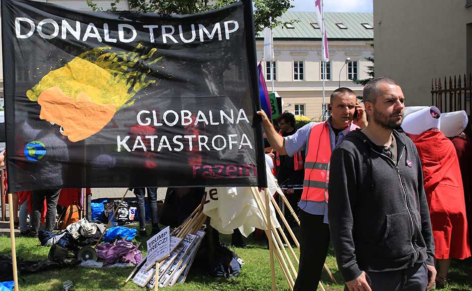 Small scale protests were held during Trump's visit. In this image, a man stands in front of a banner against the US president ahead of his public speech in Warsaw. The banner reads in Polish, "global catastrophe". Reuters Small scale protests were held during Trump's visit. In this image, a man stands in front of a banner against the US president ahead of his public speech in Warsaw. The banner reads in Polish, "global catastrophe". Reuters