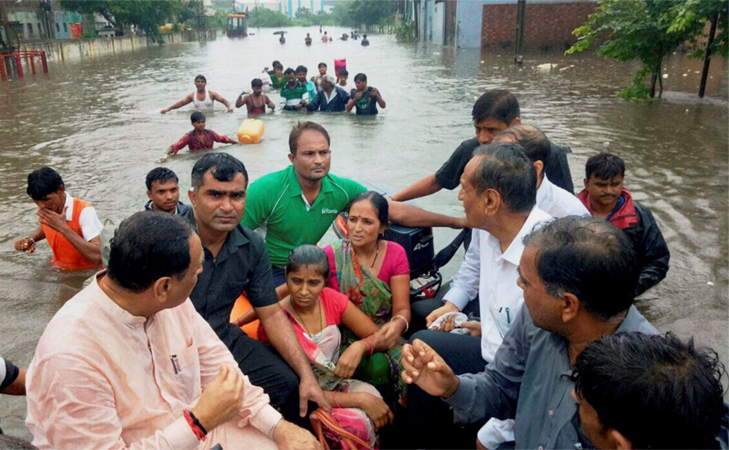 Gujarat chief minister Vijay Rupani with the flood affected people as many areas remain inundated by waters after heavy rains in Ahmedabad on Thursday. PTI Gujarat chief minister Vijay Rupani with the flood affected people as many areas remain inundated by waters after heavy rains in Ahmedabad on Thursday. PTI