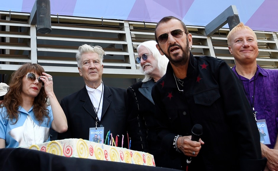 Starr, right, throws a bracelet with the inscription "Peace & Love" to the crowd. In the background from left are singer Jenny Lewis, filmmaker David Lynch and musician Edgar Winter. Photo by AP Starr, right, throws a bracelet with the inscription "Peace & Love" to the crowd. In the background from left are singer Jenny Lewis, filmmaker David Lynch and musician Edgar Winter. Photo by AP