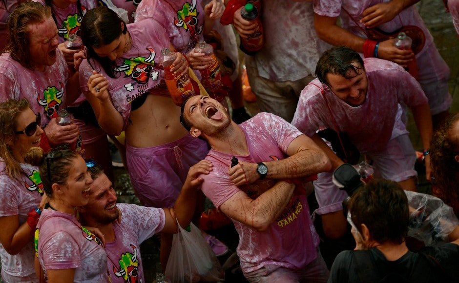Revellers on the streets douse themselves with wine and water as the celebrations continue through the day. AP Revellers on the streets douse themselves with wine and water as the celebrations continue through the day. AP