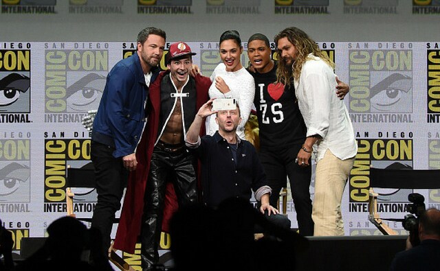(L-R) Actors Ben Affleck, Ezra Miller, Gal Gadot, Ray Fisher, and Jason Momoa from Justice League attend the Warner Bros. Pictures Presentation while moderator Chris Hardwick takes a selfie during Comic-Con International 2017. (Getty Images) (L-R) Actors Ben Affleck, Ezra Miller, Gal Gadot, Ray Fisher, and Jason Momoa from Justice League attend the Warner Bros. Pictures Presentation while moderator Chris Hardwick takes a selfie during Comic-Con International 2017. (Getty Images)