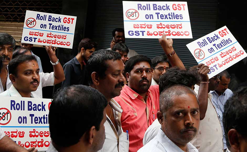 While the measure is being billed as making doing business easier by simplifying the tax structure and ensuring greater compliance, businesses, particularly small traders, are nervous about the new tax filing system. Indian textile traders hold placards as they walk past closed shops during a protest against the implementation of the nationwide GST in Bangalore. AP While the measure is being billed as making doing business easier by simplifying the tax structure and ensuring greater compliance, businesses, particularly small traders, are nervous about the new tax filing system. Indian textile traders hold placards as they walk past closed shops during a protest against the implementation of the nationwide GST in Bangalore. AP