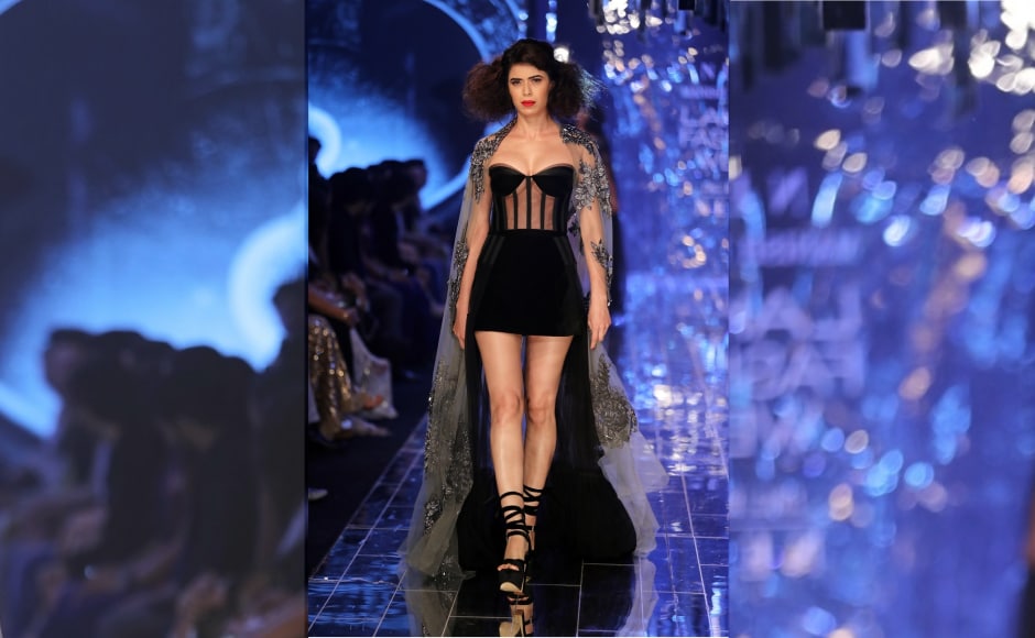 Malhotra's collection saw minis with never-ending trails and ornate leaf embroidery worn with demure black long sheer coats. Malhotra's collection saw minis with never-ending trails and ornate leaf embroidery worn with demure black long sheer coats.