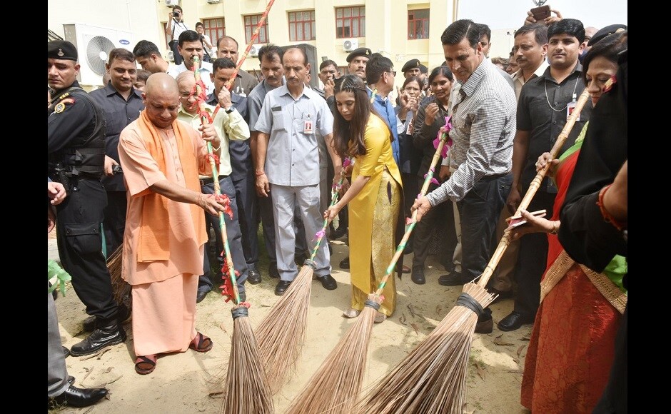 Yogi Adityanath, Bhumi Pednekar and Akshay Kumar pick up brooms and sweep the venue of the event. Image from Twitter Yogi Adityanath, Bhumi Pednekar and Akshay Kumar pick up brooms and sweep the venue of the event. Image from Twitter