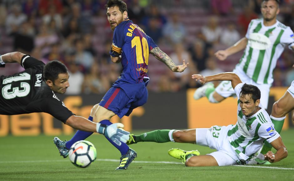 Barcelona's Lionel Messi looks on as Betis defender Alin Tosca diverts Gerard Deulofeu cross into his own net to give Barcelona the lead. AFP Barcelona's Lionel Messi looks on as Betis defender Alin Tosca diverts Gerard Deulofeu cross into his own net to give Barcelona the lead. AFP