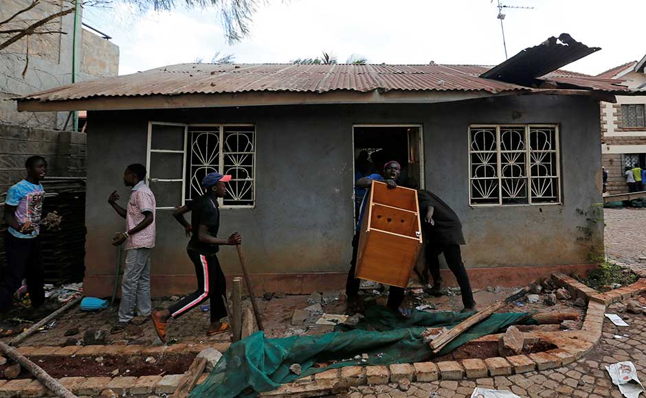 Thursday's vote had a sharply lower turnout because of the opposition boycott. About 6.5 million people, or one-third of registered voters, went to the polls, according to the election commission. Nearly 80 percent of registered voters participated in the August election. Rioters carry furniture out of a house as they loot a property in Kawangware slum. Reuters