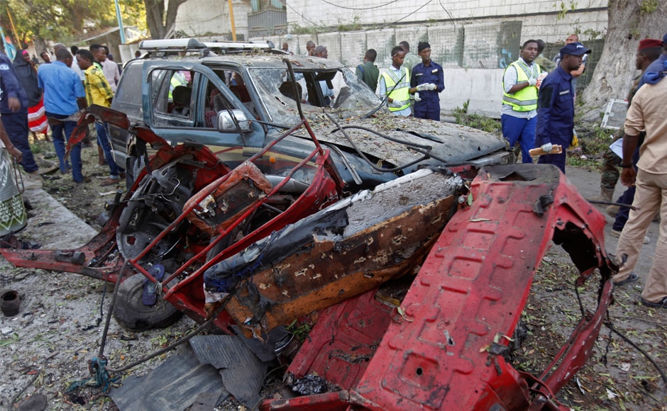 Rescue workers stand near the wreckage of vehicles in Mogadishu. A Somali police officer said security forces ended a night-long siege at the hotel. AP Rescue workers stand near the wreckage of vehicles in Mogadishu. A Somali police officer said security forces ended a night-long siege at the hotel. AP
