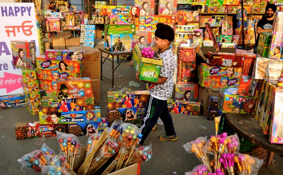 A child buying firecrackers on the eve Diwali festival, in Amritsar on Wednesday. PTI India's streets deck up with lanterns, diyas as people gear up to celebrate Diwali