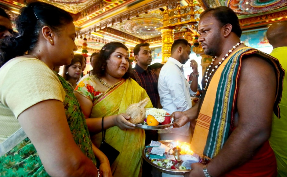 A priest receives offerings from Hindu devotees at a temple during Diwali celebration in Kuala Lumpur, Malaysia, on Wednesday. Diwali or Deepawali, also known as Festival of Light, is celebrated by Hindus as the new beginning and the triumph of good over evil and light over darkness. AP India's streets deck up with lanterns, diyas as people gear up to celebrate Diwali