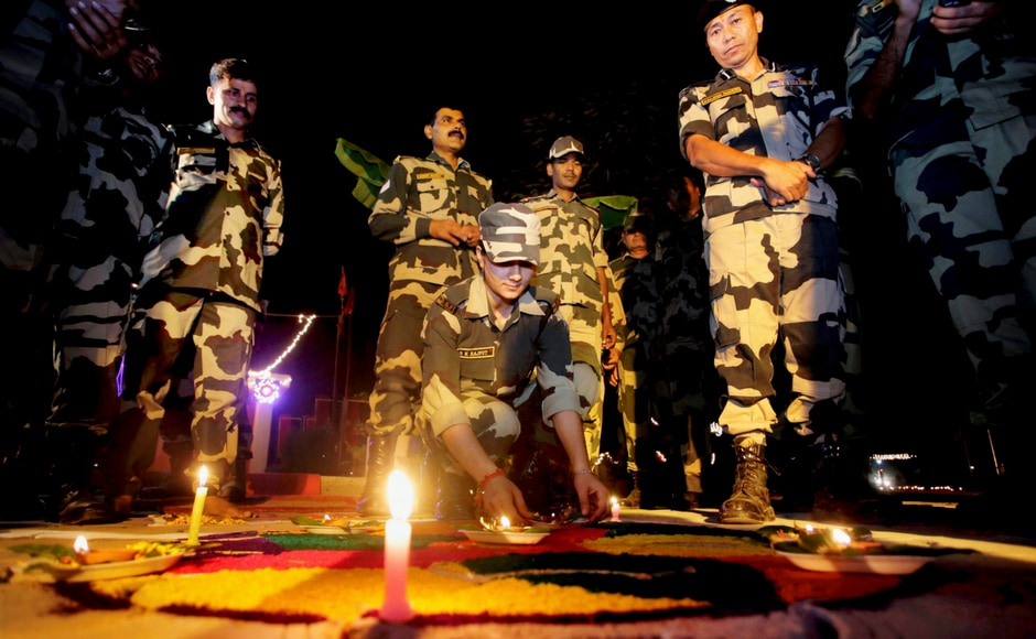 Border security force (BSF) soldiers light candles near the International Border fence at Pargwal about 40 kilometres from Jammu on Wednesday. India's streets deck up with lanterns, diyas as people gear up to celebrate Diwali