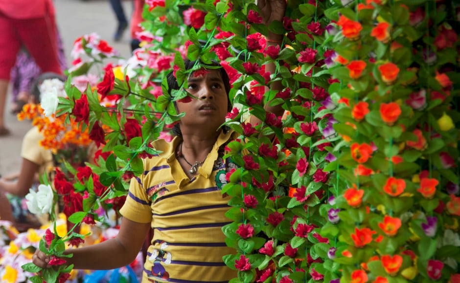 A young vendor arranges artificial flowers at his shop ahead of Diwali in Hyderabad on Tuesday. AP India's streets deck up with lanterns, diyas as people gear up to celebrate Diwali