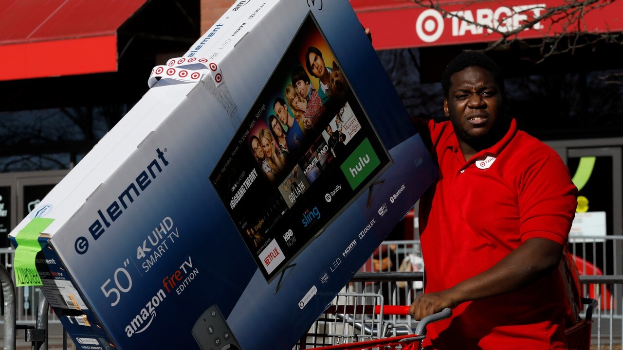 A man pushes a cart load of goods outside of a Target store during Black Friday shopping. Image: Reuters