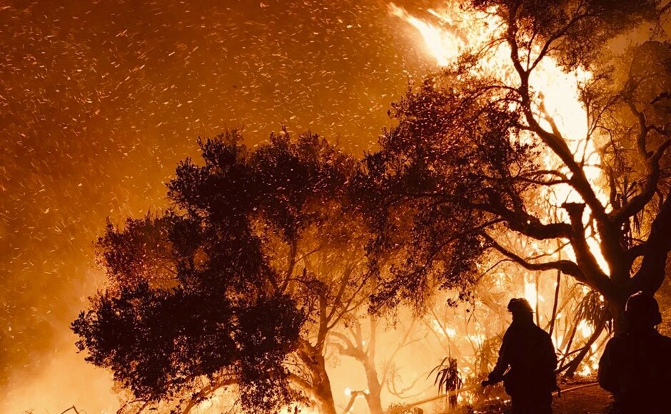 A powerful flare-up on the western edge of Southern California's largest and most destructive wildfire sent residents fleeing Sunday, as wind-fanned flames churned through old-growth brush in canyons and along hillsides toward coastal towns. AP A powerful flare-up on the western edge of Southern California's largest and most destructive wildfire sent residents fleeing Sunday, as wind-fanned flames churned through old-growth brush in canyons and along hillsides toward coastal towns. AP