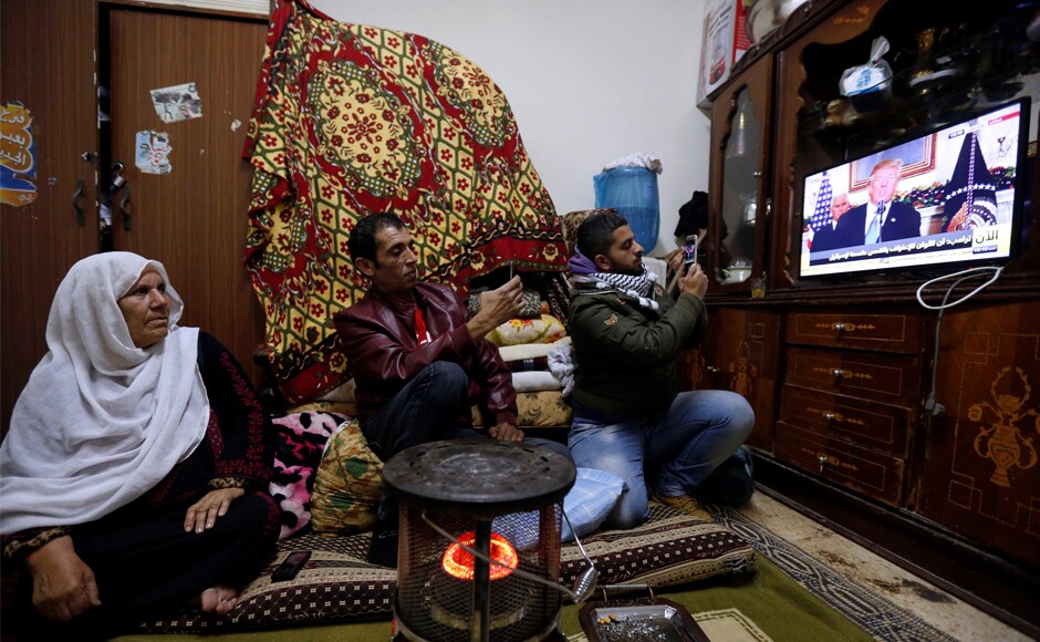A Palestinian refugee family watches a televised broadcast of the announcement, at a refugee camp, near Amman in Jordan. Trump's announcement sparked protests across the Arab world with Palestine president Mahmoud Abbas saying it signalled US withdrawal from being a peace mediator. Reuters A Palestinian refugee family watches a televised broadcast of the announcement, at a refugee camp, near Amman in Jordan. Trump's announcement sparked protests across the Arab world with Palestine president Mahmoud Abbas saying it signalled US withdrawal from being a peace mediator. Reuters