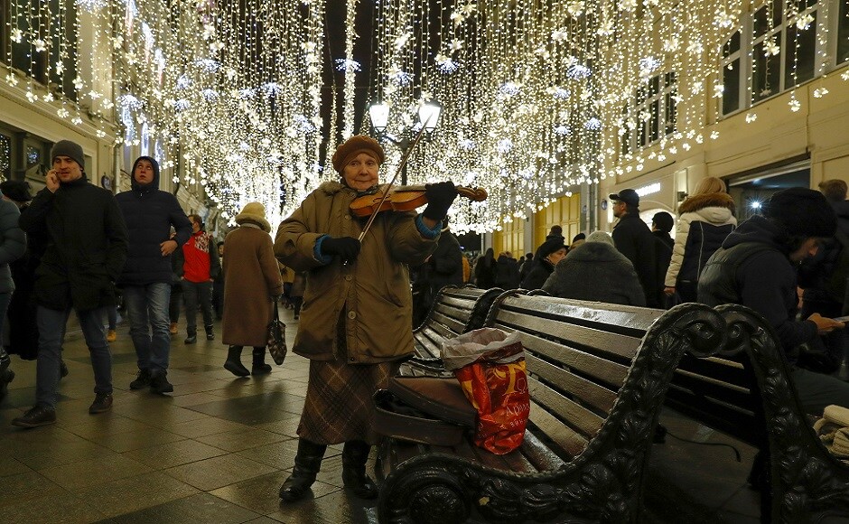 A woman plays a violin on the street, decorated with festive lights prior to the New Year and Christmas holidays, in central Moscow, Russia. REUTERS Christmas around the world: Lights, Santa hats and good cheer mark festivities