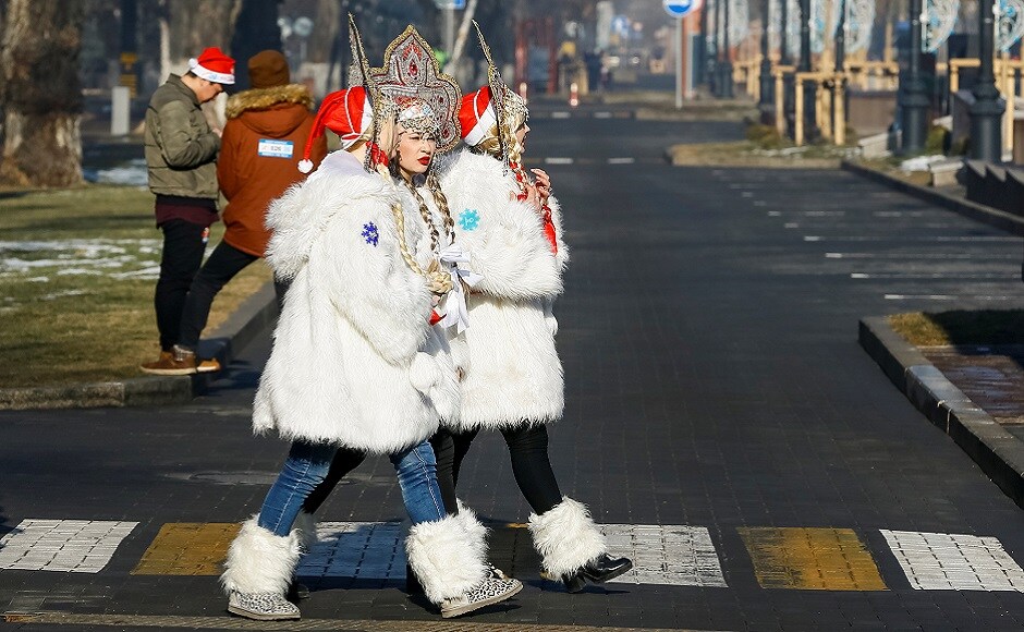 Revellers walk across a street during a parade to celebrate the upcoming Christmas and New Year in Almaty, Kazakhstan. REUTERS Christmas around the world: Lights, Santa hats and good cheer mark festivities